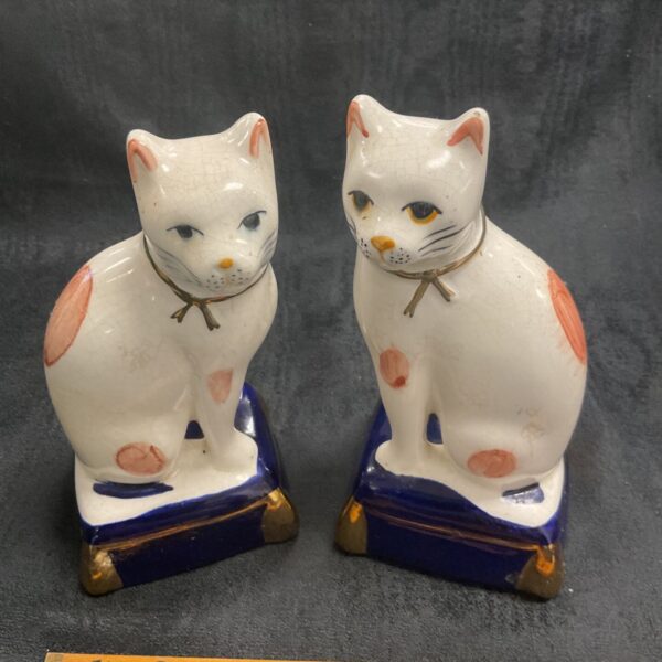 Pair of vintage Staffordshire cats with floral decoration.