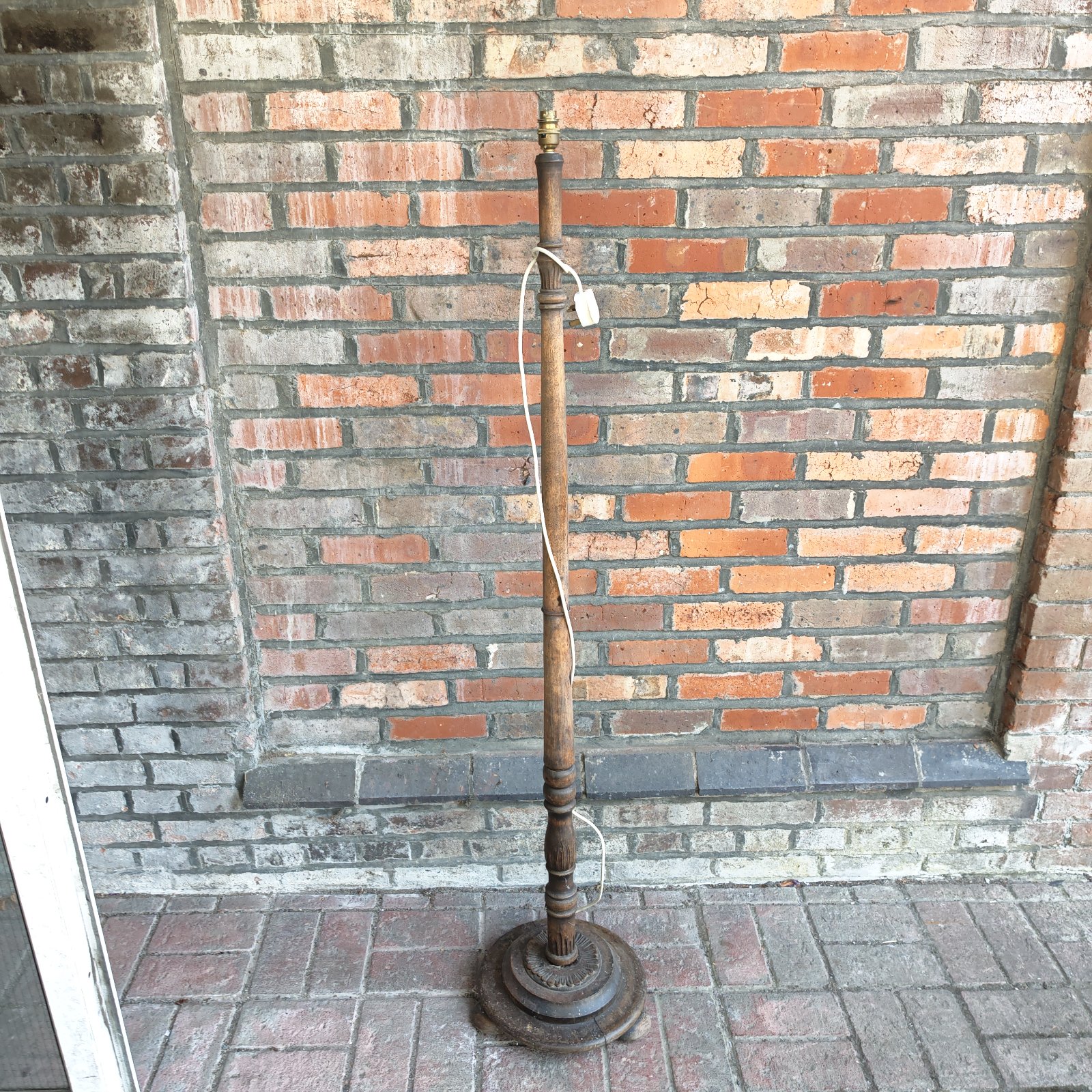 Vintage standard lamp with wooden column and circular base.
