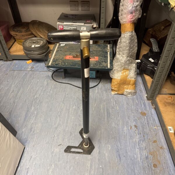 Vintage stirrup pump with metal body and foot pedal.