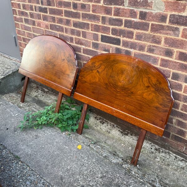 Two vintage walnut headboards leaning against a wall.