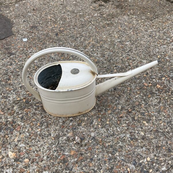 Vintage white metal watering can for garden use.