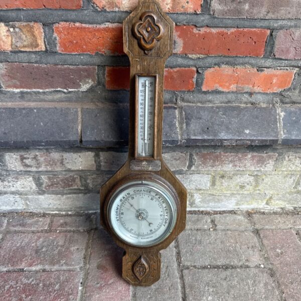 Vintage wooden aneroid barometer with cracked glass dial.