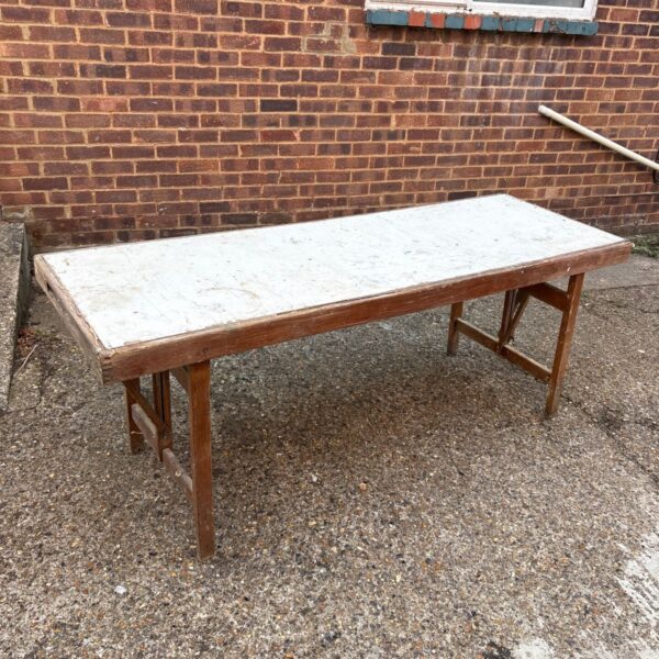 Large vintage wooden folding work table with weathered surface.