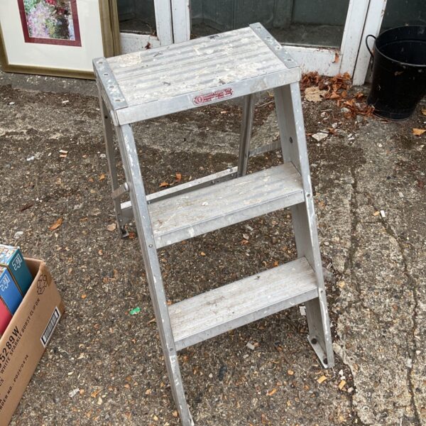 Vintage wooden three-step ladder, showing signs of age.
