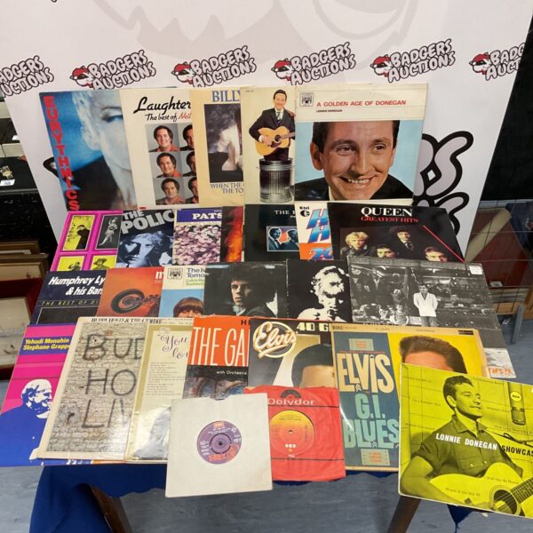 Vintage vinyl record collection featuring Queen and The Police albums.