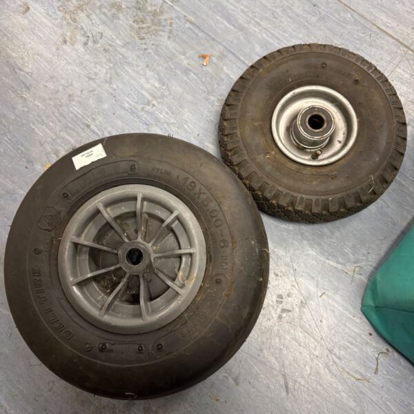 Close-up of a wheelbarrow wheel with a pneumatic tyre.