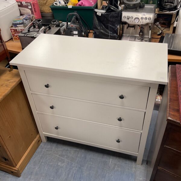 White chest of drawers with three drawers, ideal for bedroom storage.
