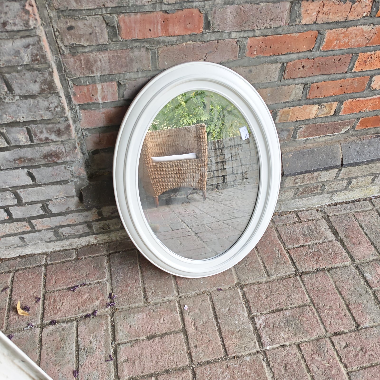 White plastic framed oval wall mirror for home decor.