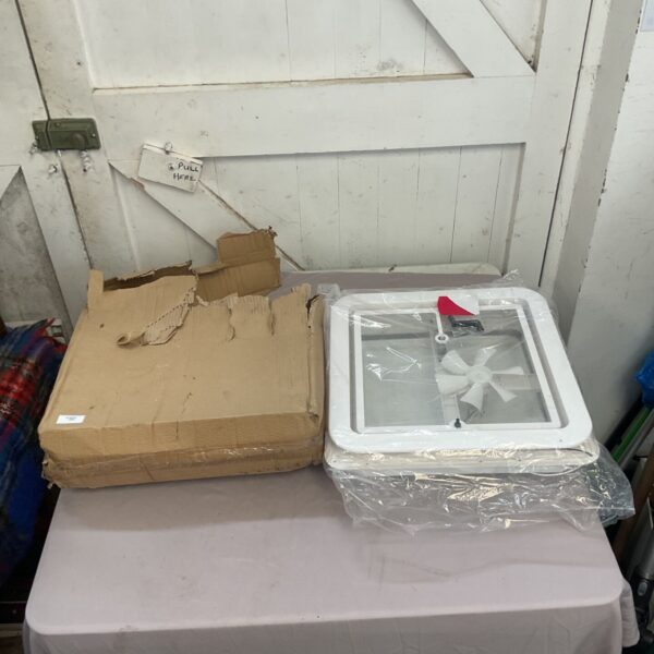 White roof vent in damaged cardboard packaging.