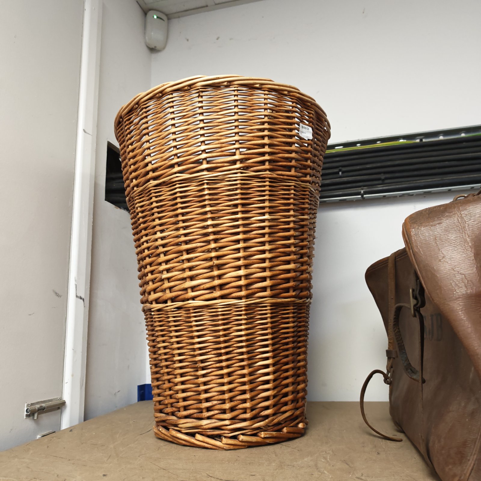 Tall vintage wicker wash basket for laundry and storage.