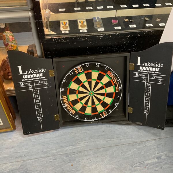 Winmau Blade dartboard cabinet in dark wood finish.