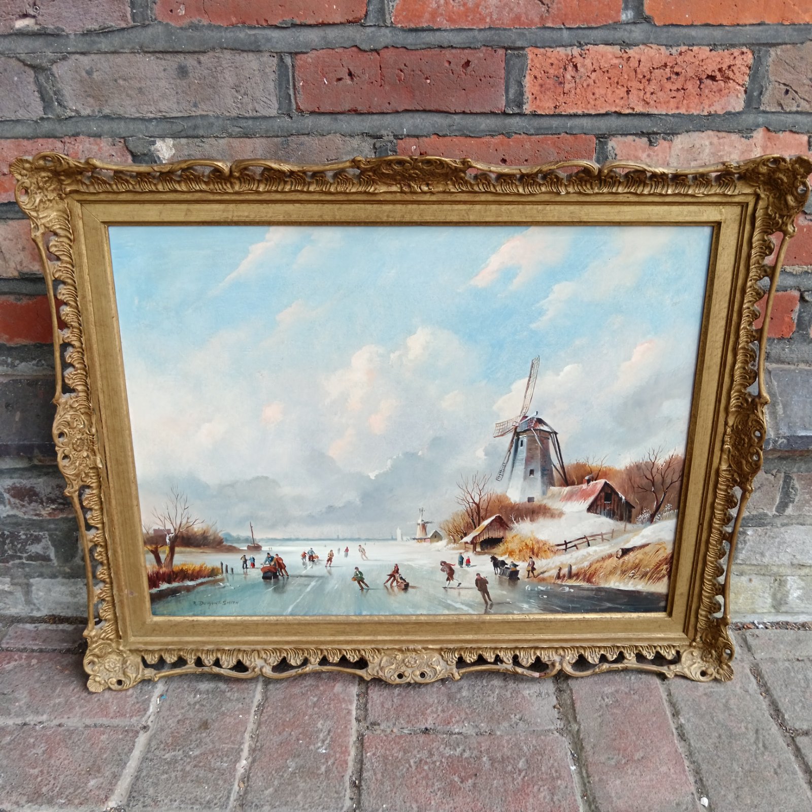 Vintage winter landscape painting with skaters and a windmill.
