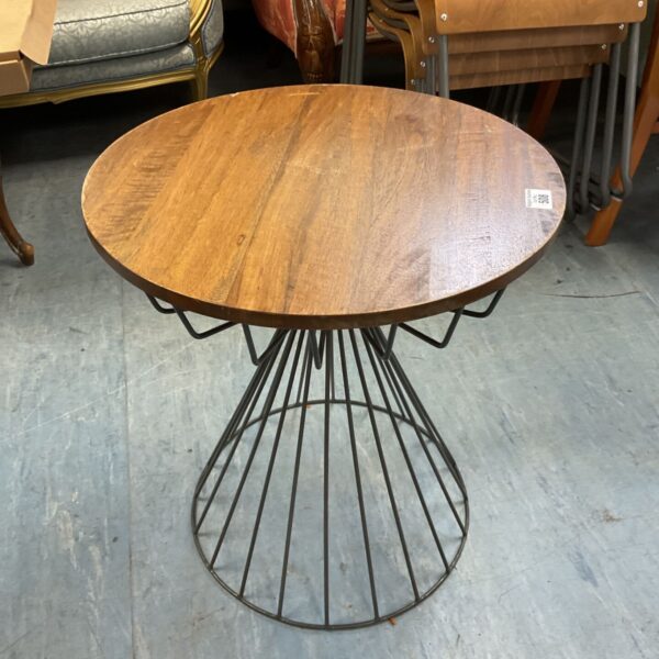 Industrial wire frame wine table with circular top and metal base.