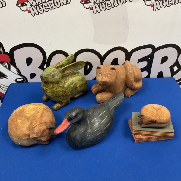 Collection of hand-carved wooden animals including a duck, rabbit and cat.