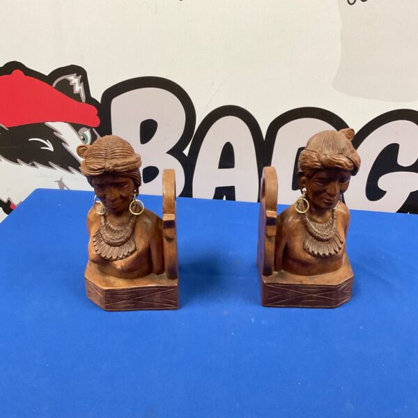 Handcrafted wooden bookends with carved indigenous figures.