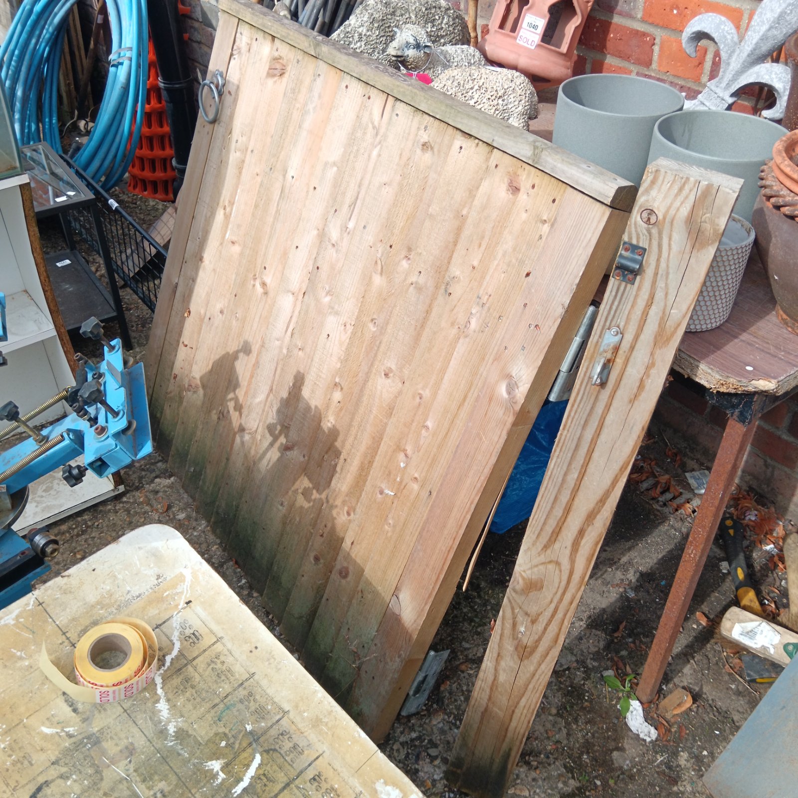 Rustic wooden garden gate with supporting post, ideal for garden projects.