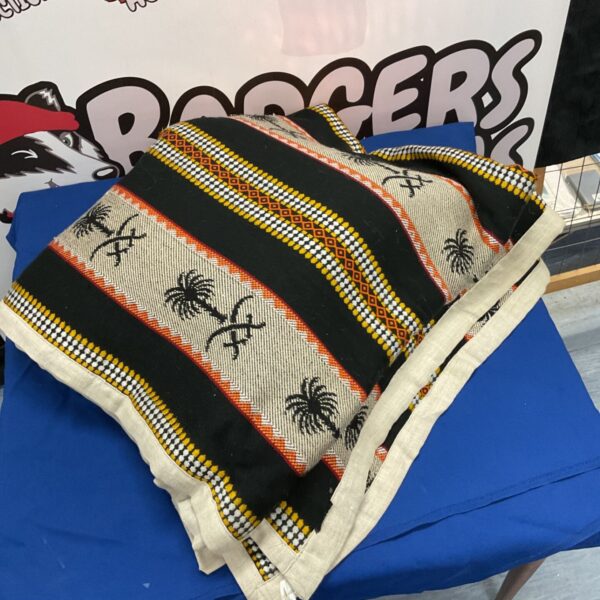 Woven textile throw with Arabic geometric and palm tree pattern.