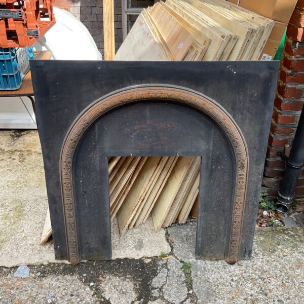 Antique wrought iron fire surround with ornate detailing.