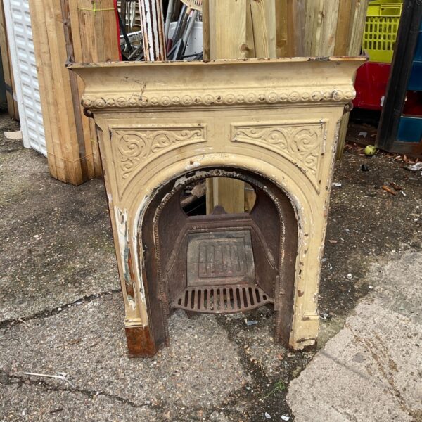 Antique wrought iron fireplace with intricate Victorian detailing.
