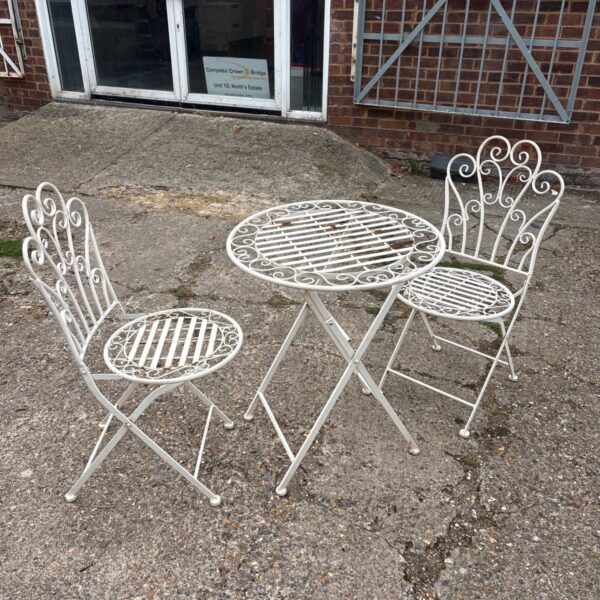 Vintage wrought iron garden set with table and two chairs.