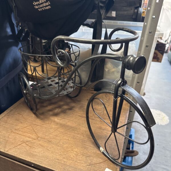 Vintage wrought iron tricycle plant stand for garden display.
