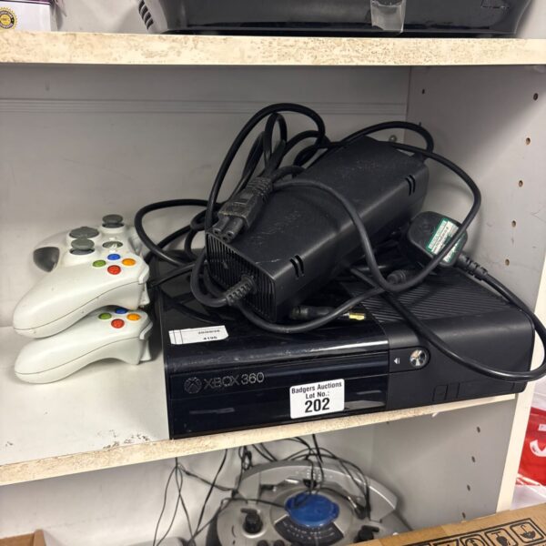 Xbox 360 console with controllers and cables for gaming.