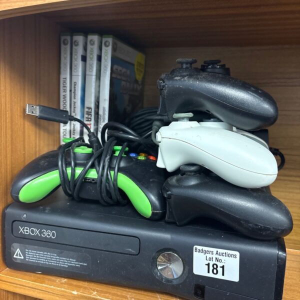 Xbox 360 console with games and controllers displayed.