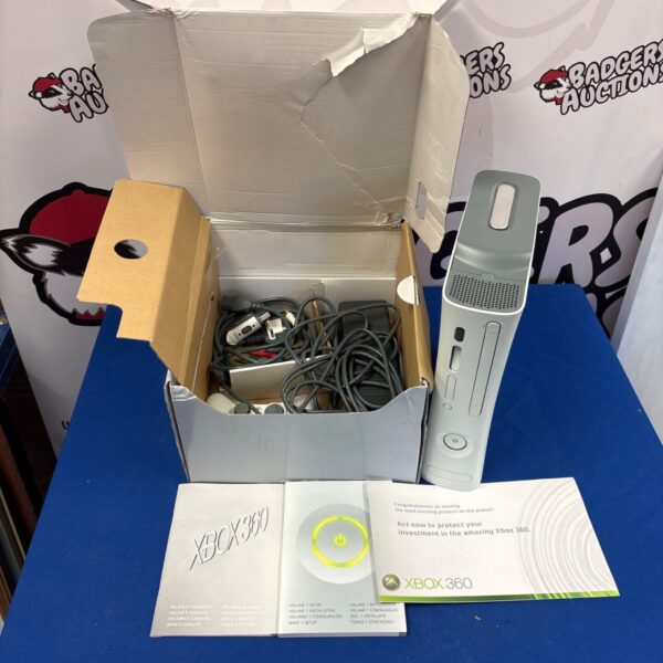 Boxed Xbox 360 E console with controller and manuals.