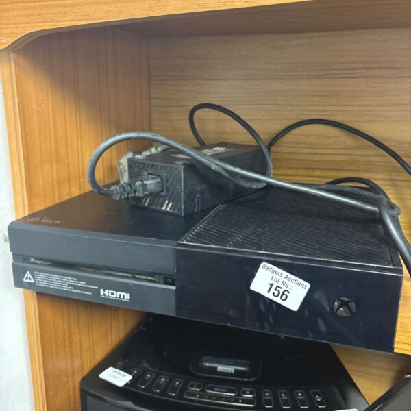 Black Microsoft Xbox One console with power supply for gaming.