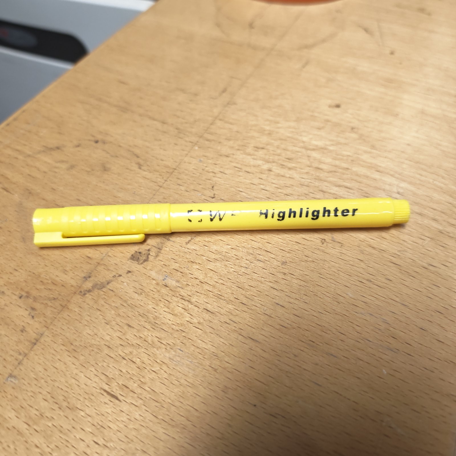 Yellow highlighter pen for marking and emphasizing text.