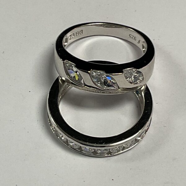 Two 925 silver rings with white CZ stones on a light background
