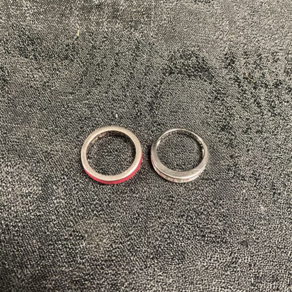 Pair of 925 silver rings on a dark textured fabric surface