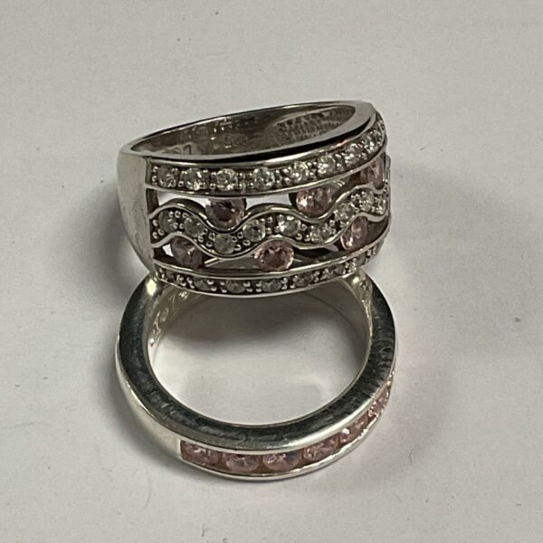 Two 925 silver rings with pink and white stones on a grey surface
