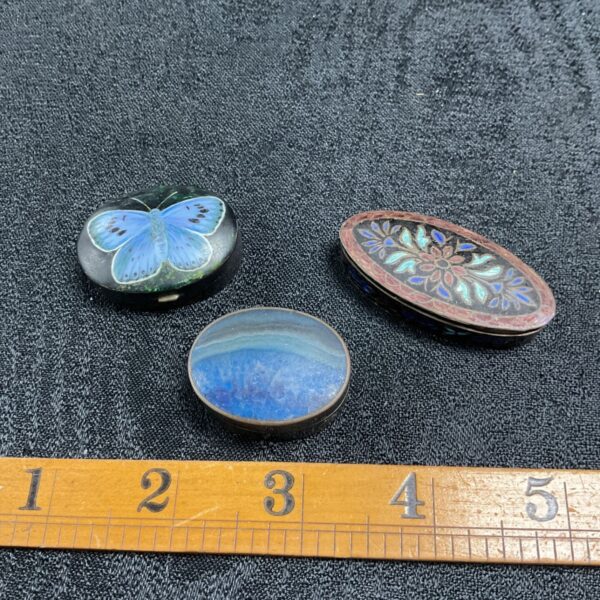 Three 925 sterling silver enamelled pill pots with blue butterfly and floral designs