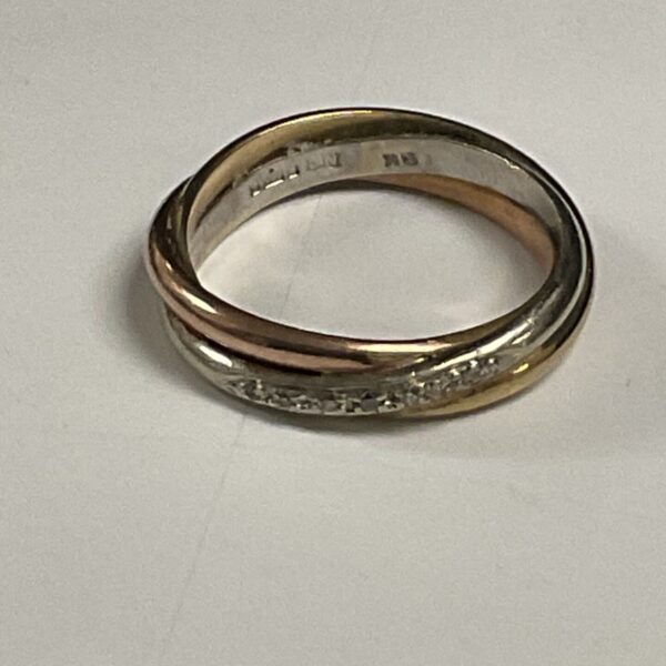 Close-up of a 9ct gold diamond ring with tri-colour bands.