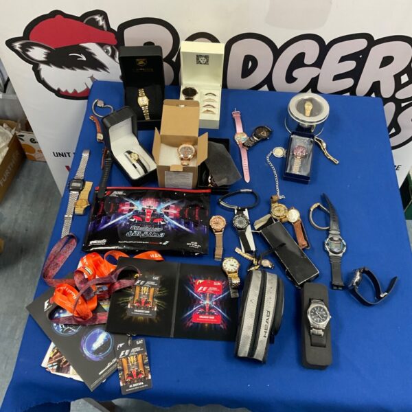 Large mixed lot of wristwatches and Abu Dhabi Grand Prix memorabilia on a blue table
