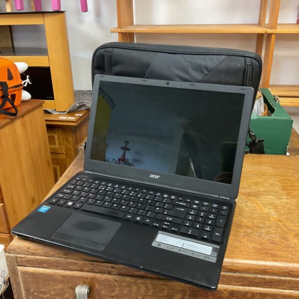 Black Acer Aspire E1-510 laptop with carry case on wooden chest