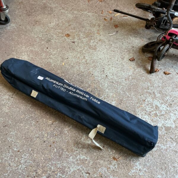 Navy carry bag labelled Aluminium Double Roll-Up Table FUT150 on a concrete floor