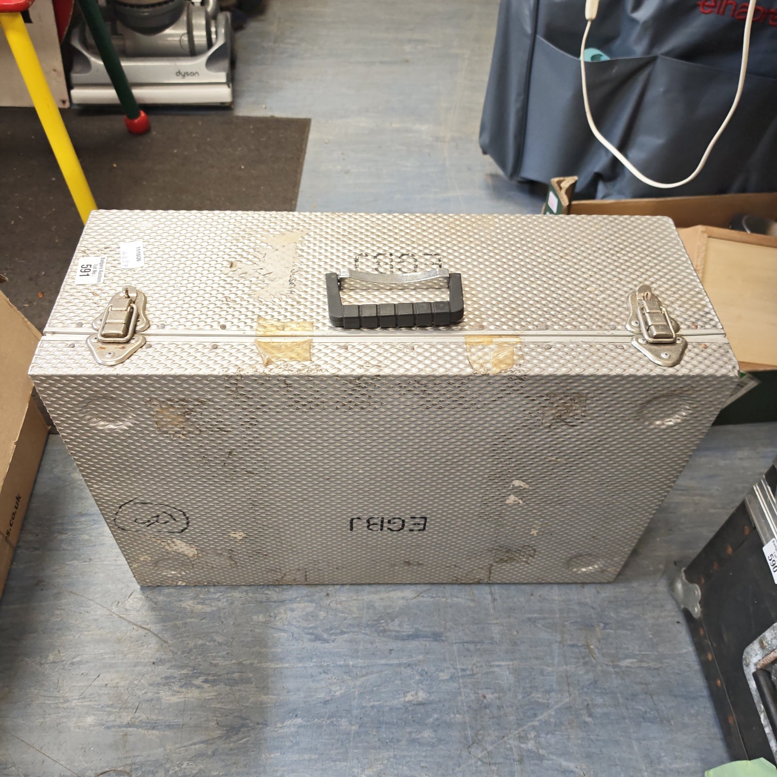 Front view of a used aluminium flight case with a handle.