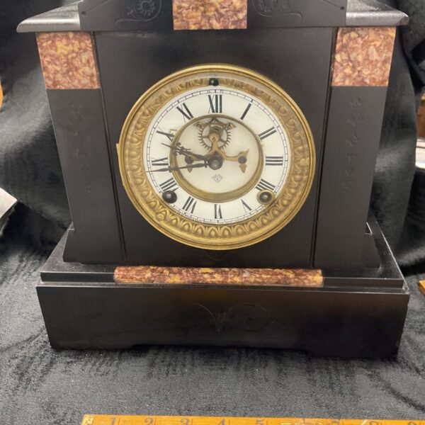 Antique Ansonia slate mantle clock with marble details.