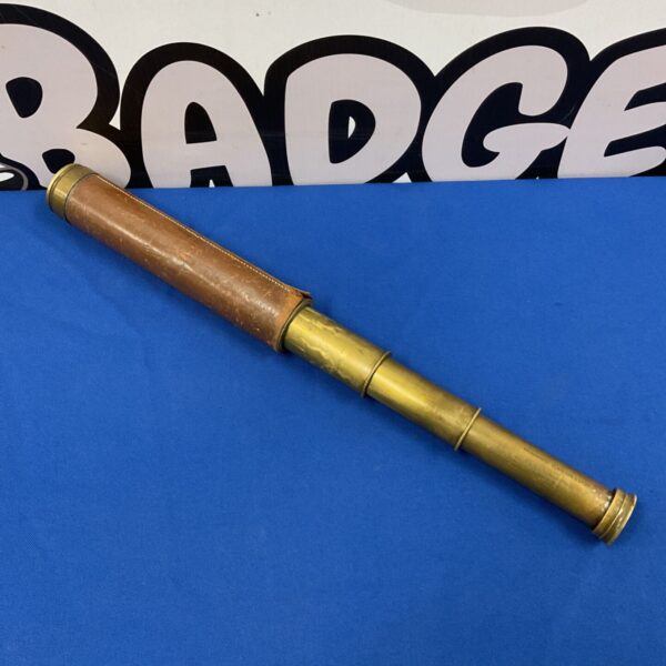 Antique brass telescope with leather wrap, a collectible nautical instrument.