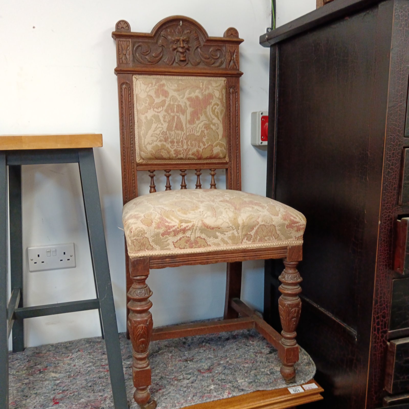 Antique carved oak chair with green man detail.