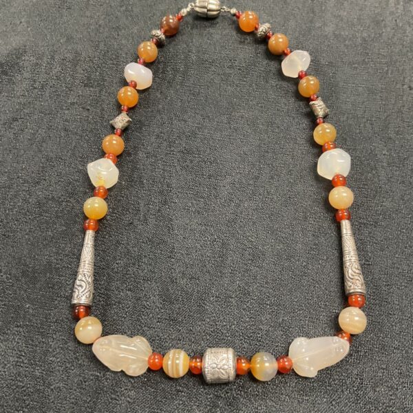 Antique carved stone necklace with white jade and silver details.