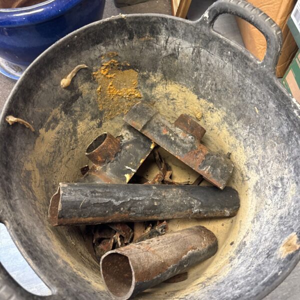 Bucket of antique cast iron drainpipe parts and fittings.