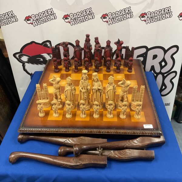 Antique chess set displayed on a mahogany chessboard table.
