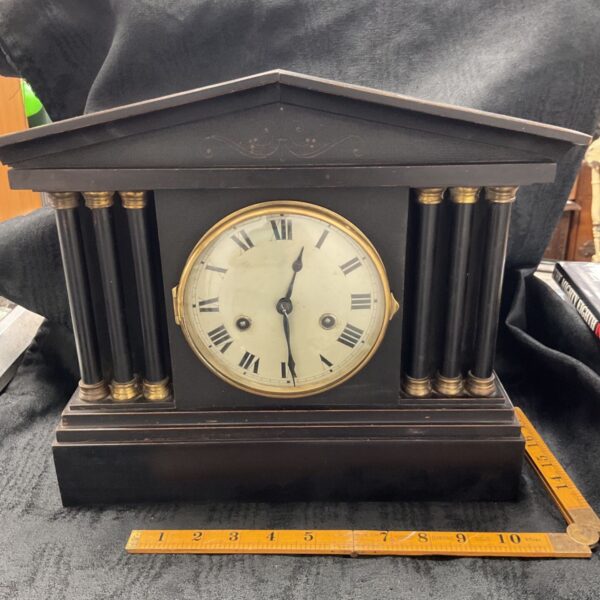 Antique German mantle clock with six columns and Roman numeral face.