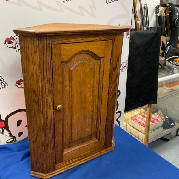 Antique oak corner cupboard with raised panel door.