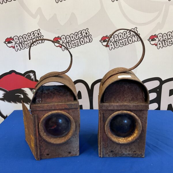 Pair of antique railway lanterns with protective cages.
