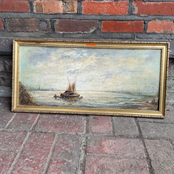 Antique seascape painting of a sailing barge with a gold frame.