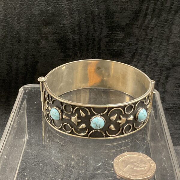 Antique silver cuff bracelet with turquoise stones, detailed filigree work.